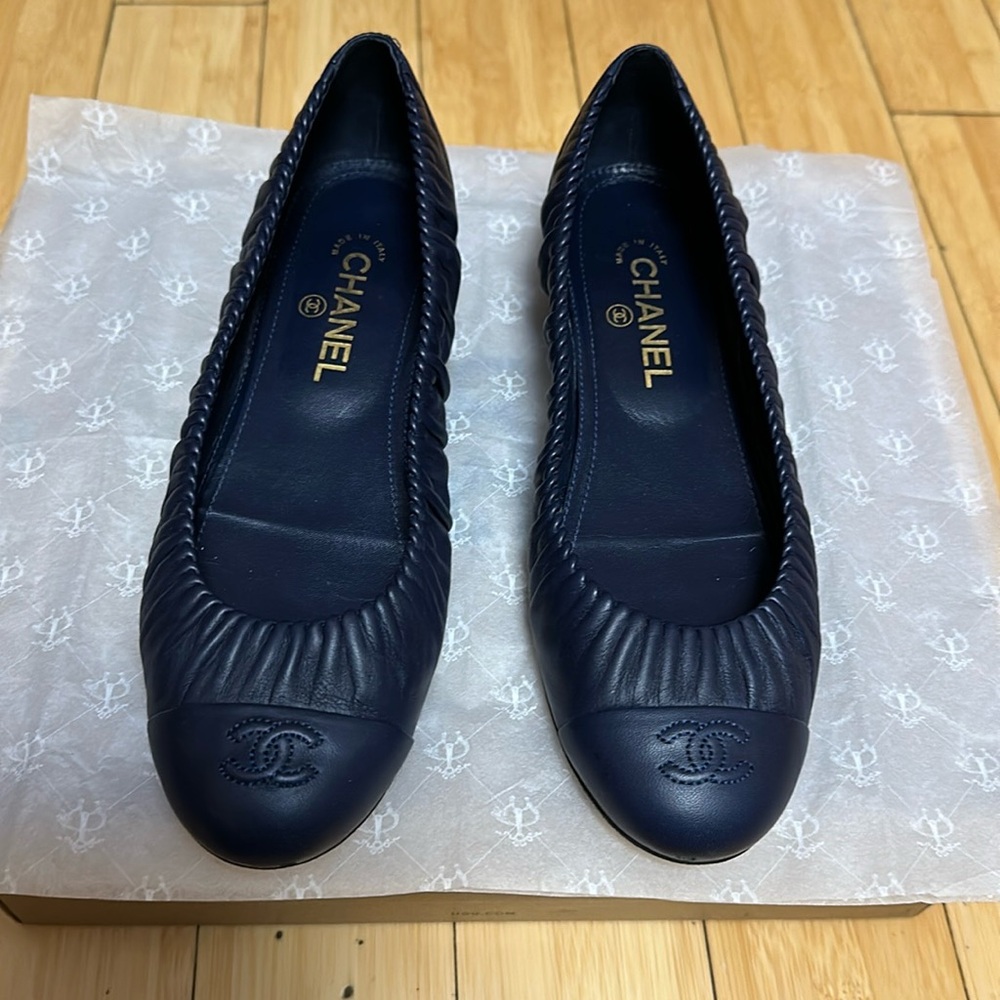 Chanel navy flats with gold heel.